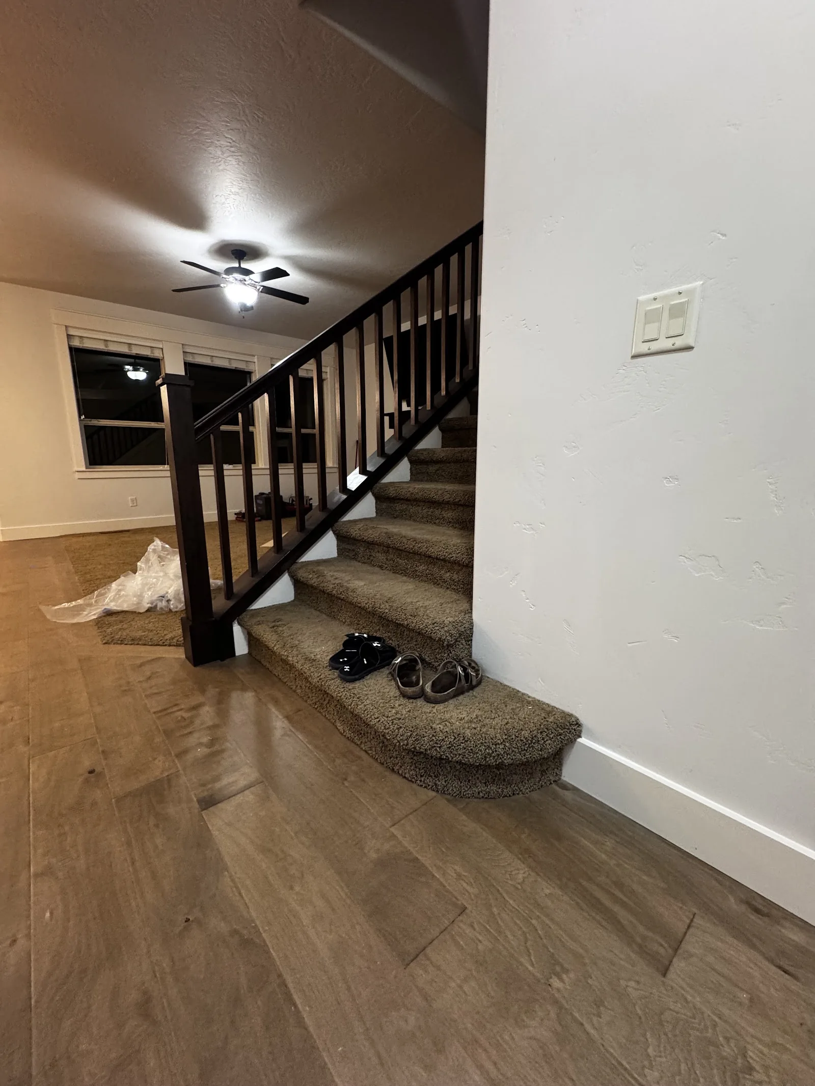 Wood staircase beside an engineered hardwood hallway floor