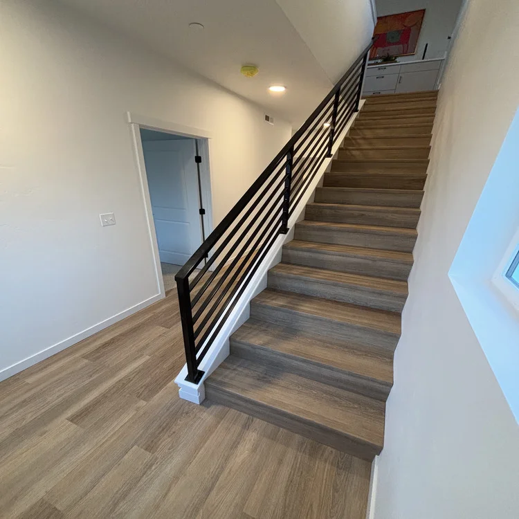 Wood-look luxury vinyl plank flooring on a staircase and hallway in a two-story home
