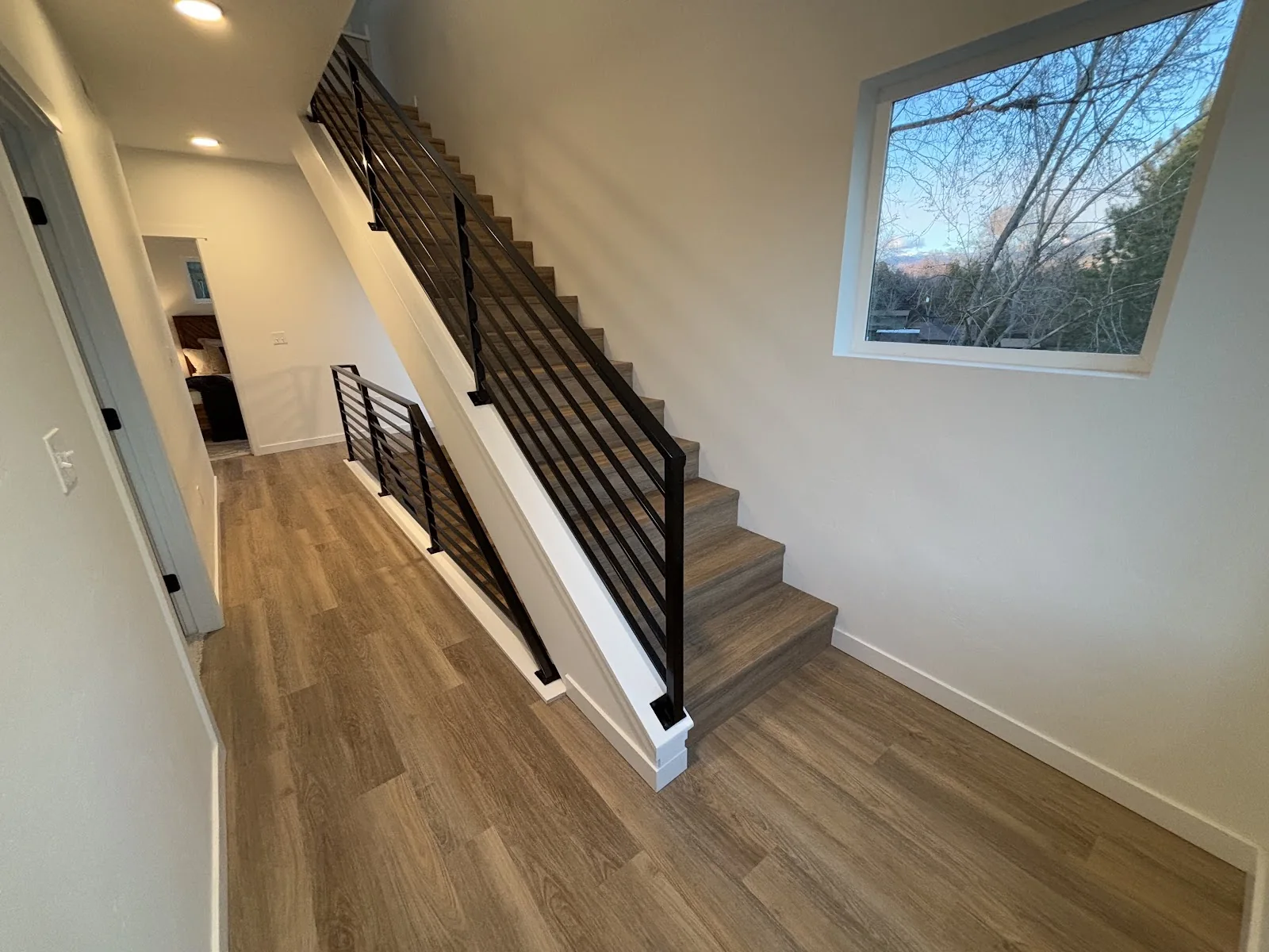 Oak-look luxury vinyl plank around a staircase landing