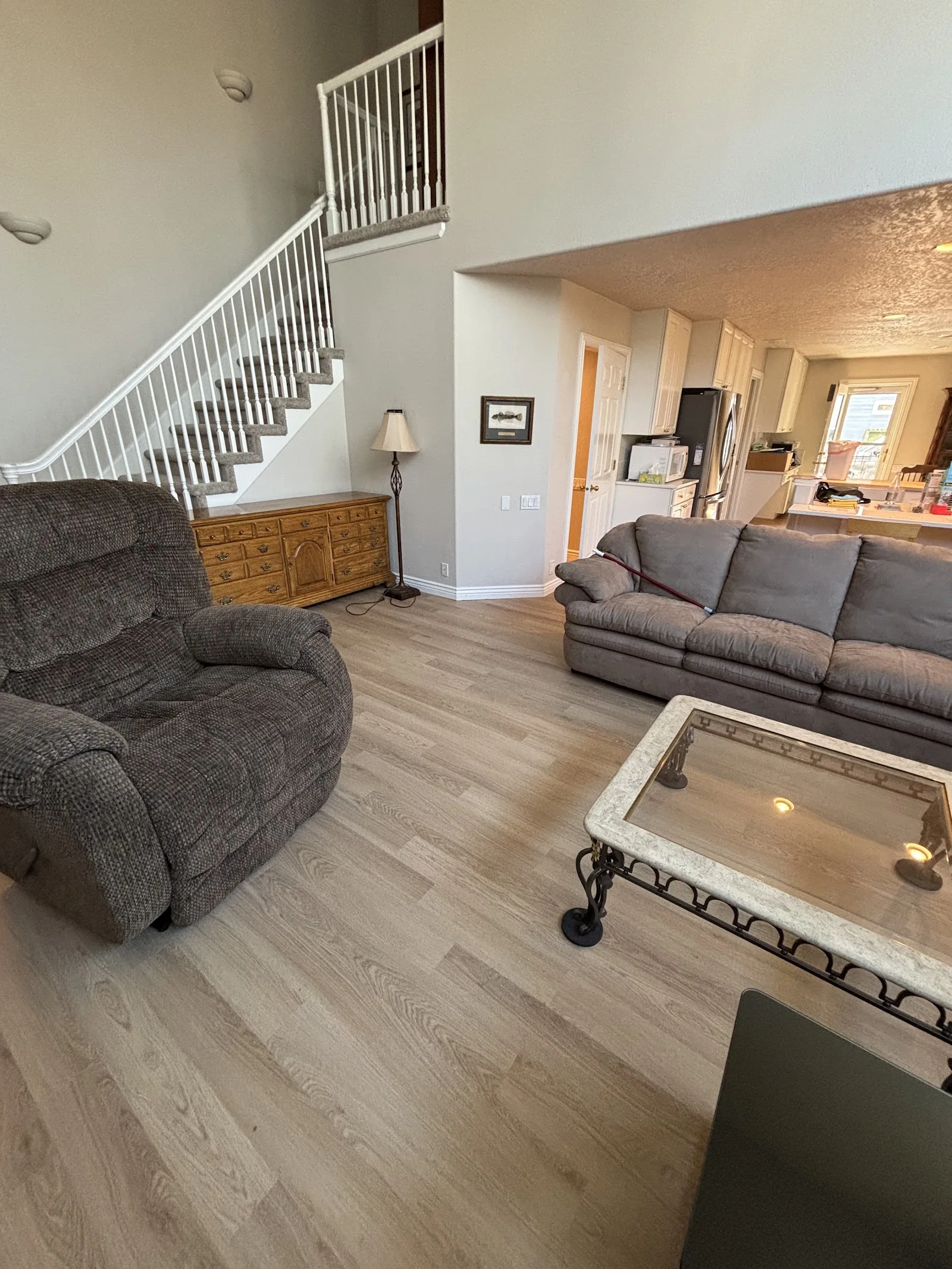 Wood-look luxury vinyl plank beside a living room staircase