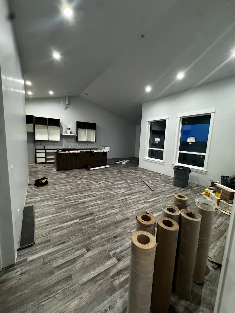 New luxury vinyl plank flooring being installed across an open room