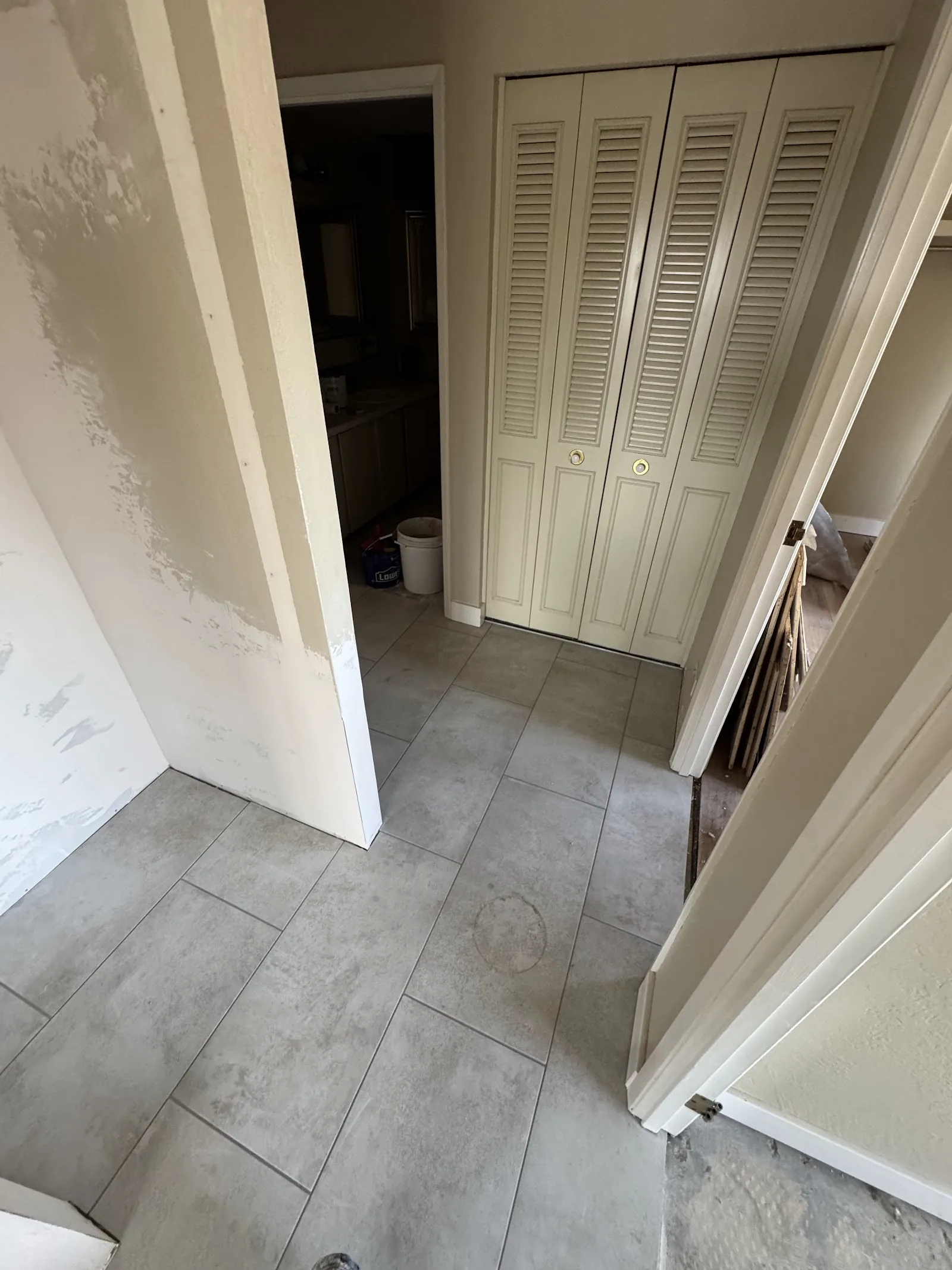 Newly laid tile flooring in a hallway mid-renovation